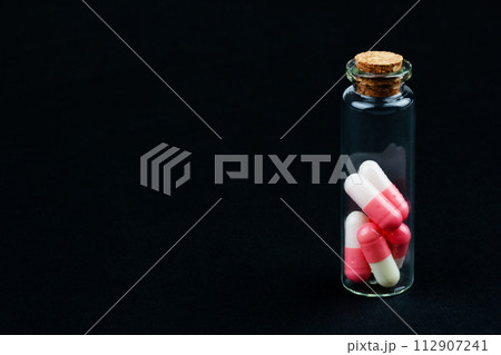 glass jar with colorful pills glass jar with colorful pills 112907241