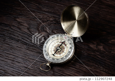 Vintage retro compass on wooden background 112907248