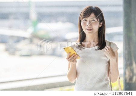 空港　窓辺　女性　スマホ 112907641