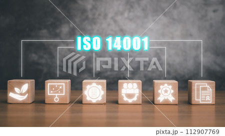 Iso 14001 concept, Wooden block on desk with iso 14001 icon on virtual screen. 112907769