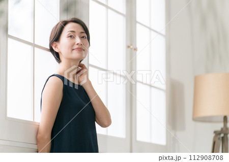 窓際に立つ美しいミドル女性 窓際に立つ美しいミドル女性 112908708