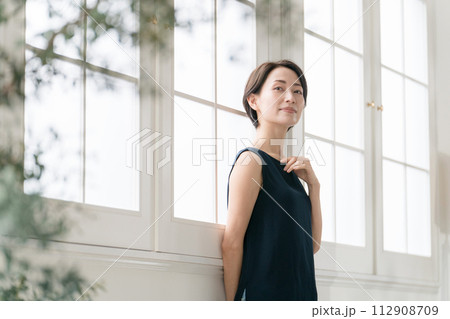 窓際に立つ美しいミドル女性 112908709
