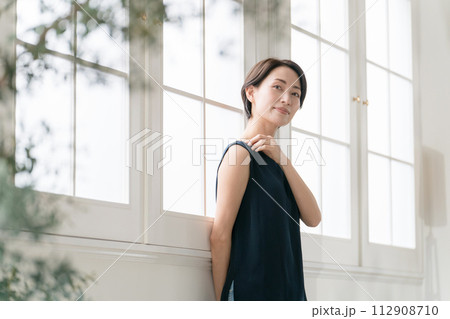 窓際に立つ美しいミドル女性 112908710