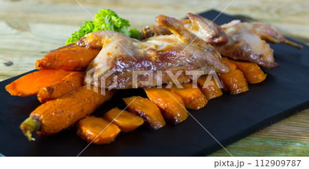 Tasty quail of teriyaki with carrots, fried on a grill, served with greens Tasty quail of teriyaki with carrots, fried on a grill, served with greens 112909787