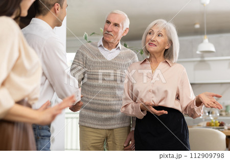 Elderly parents greeting grown son with wife at family get-together 112909798