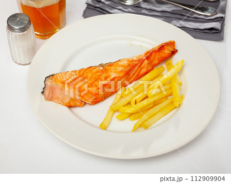 Tasty grilled salmon served with french fries 112909904