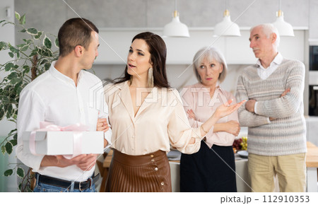 Woman welcoming boyfriend home while senior parents disapproving 112910353