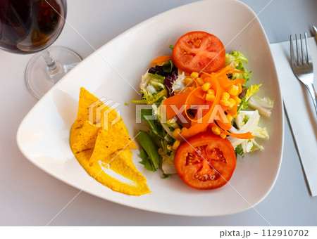 Fresh vegetable salad with hummus and nachos 112910702