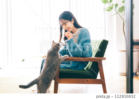 自宅で猫と遊ぶ女性 112910832
