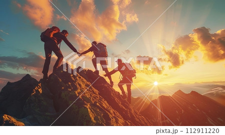 Three people helping each other reach the top of the mountain during sunset. Conceptual scene with teamwork 112911220