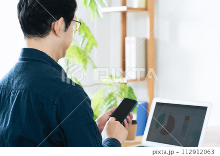 スマホを見る男性 112912063