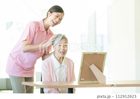 若い介護士とシニア女性 112912623
