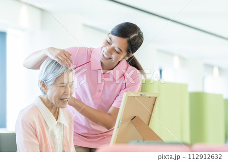 若い介護士とシニア女性 112912632