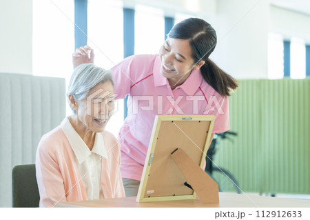 若い介護士とシニア女性 若い介護士とシニア女性 112912633