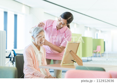 若い介護士とシニア女性 112912636