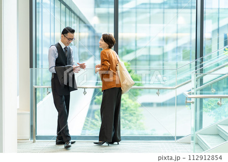 オフィスのロビーで話をするビジネスパーソン 112912854