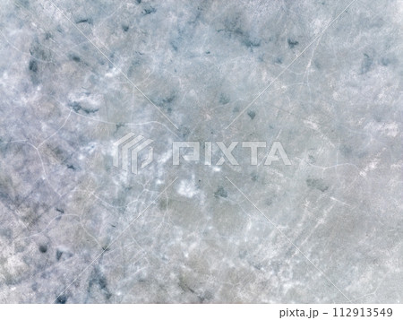 Aerial Top-Down View of Cracked, Broken, and Melting Ice on a Water Surface 112913549