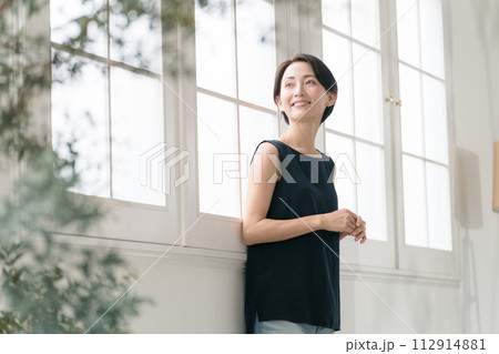 窓際に立つ美しいミドル女性 窓際に立つ美しいミドル女性 112914881