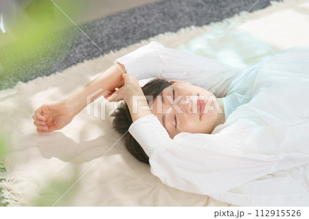 気持ちよさそうに昼寝をする女性 112915526