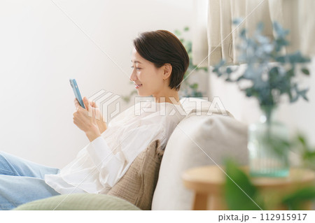 スマホを見るミドル女性の横顔 112915917