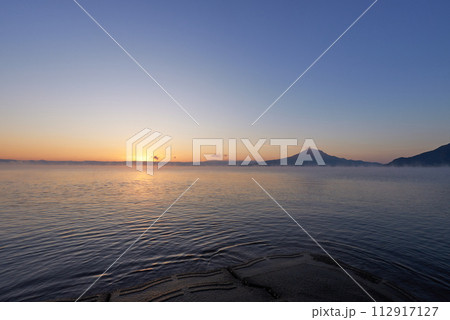 静かな海から登りはじめる太陽の光 112917127