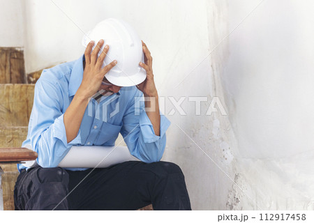 Asian young engineer man stress and failure in architecture project sitting at office on construction site. Upset despair civil construction engineer working on laptop with stressed problems Asian young engineer man stress and failure in architecture project sitting at office on construction site. Upset despair civil construction engineer working on laptop with stressed problems 112917458