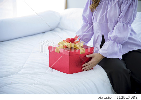 Woman surprise got present gift box on christmas eve. Asian woman holding christmas gift box under xmas tree with smiling face. Woman hands wrap present gift. Merry christmas happy new year concept Woman surprise got present gift box on christmas eve. Asian woman holding christmas gift box under xmas tree with smiling face. Woman hands wrap present gift. Merry christmas happy new year concept 112917988