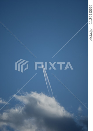 雲の上に浮かぶ飛行機雲 112918096