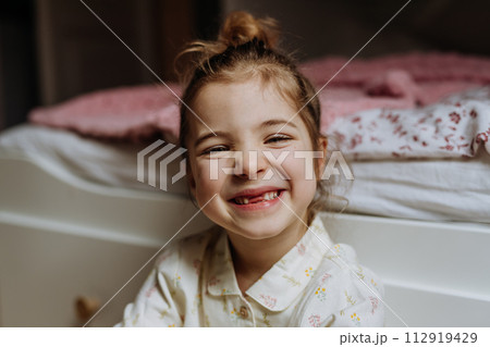 Portrait of cute girl smiling with gap-toothed grin, missing her baby teeth. Portrait of cute girl smiling with gap-toothed grin, missing her baby teeth. 112919429