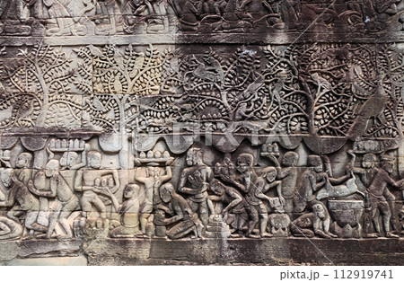 Wall carving of Prasat Bayon Temple in famous landmark Angkor Wat complex, Siem Reap, Cambodia. Bas-relief depicting peasants going about daily routine 112919741