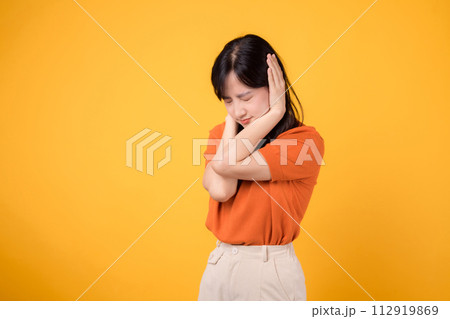 Unhappy asian woman 30s person facing noise problem, holding ear in pain. Studio portrait reflecting stress and discomfort. Unhappy asian woman 30s person facing noise problem, holding ear in pain. Studio portrait reflecting stress and discomfort. 112919869