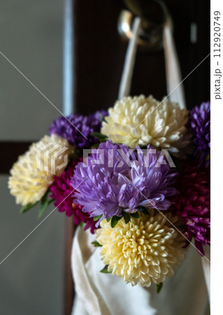 Bouquet of flowers in cotton natural bag for delivery. Copy space for text. Concept of holiday congratulation present or gift. Spring Bouquet of flowers in cotton natural bag for delivery. Copy space for text. Concept of holiday congratulation present or gift. Spring 112920749