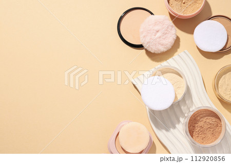 Bottles of face powder, different shades, on a pastel background. 112920856