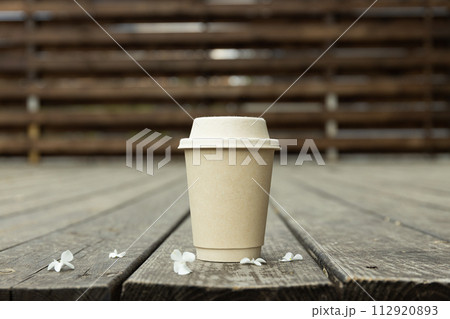 Coffee with flowers on the street, on a wooden background. 112920893