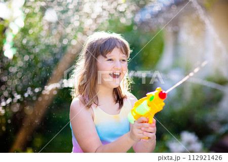 Kids with water gun toy in garden. Outdoor fun. 112921426