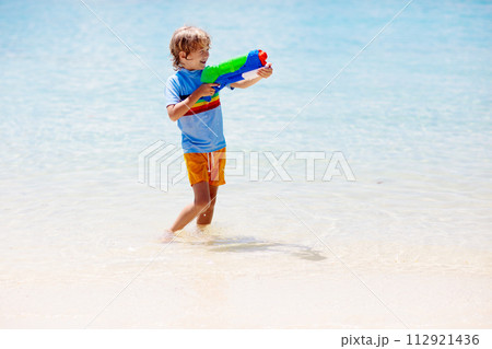 Child with toy water gun. Kids vacation beach fun. Child with toy water gun. Kids vacation beach fun. 112921436