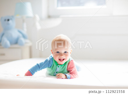 Baby boy crawling on bed Baby boy crawling on bed 112921558