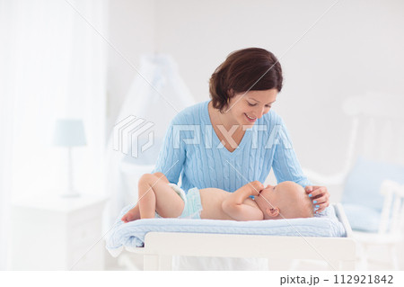 Mother changing diaper to baby boy 112921842