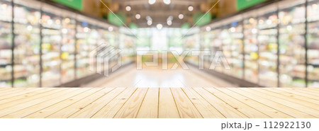 Empty wood table top with supermarket grocery store aisle and shelves blurred background 112922130