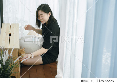 pet care concept with owner during read book and play with british cat in livingroom 112922275