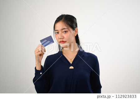 Portrait of beautiful young woman holding credit bank card isolated on white background Portrait of beautiful young woman holding credit bank card isolated on white background 112923833