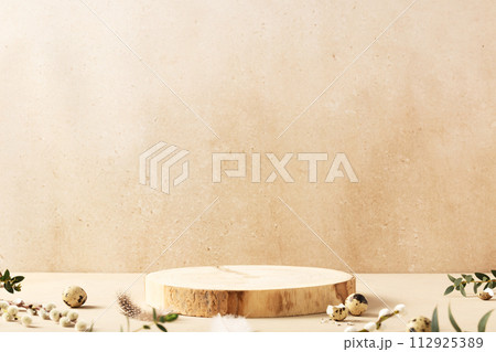 Empty round wooden podiums, quail eggs with green eucalyptus branches on a beige background 112925389
