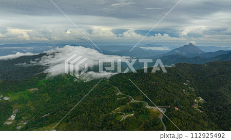 Aerial view of farmland and village of farmers in the mountains. Borneo, Sabah, Malaysia. 112925492
