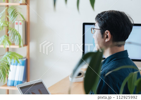 自宅でパソコンを操作するミドル男性 112925992