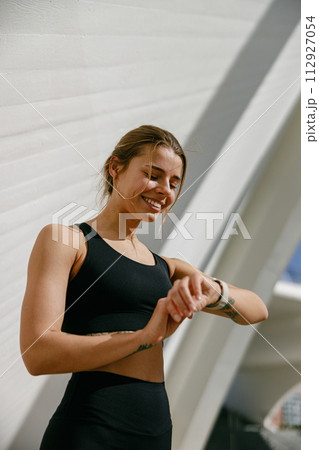 Young athlete woman looking at smartwatch and counting calories burned. Healthy life concept  112927054