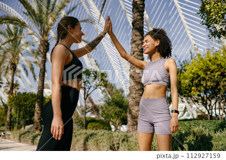 Sporty women greeting together outdoor doing gesture of shake hand after exercising 112927159