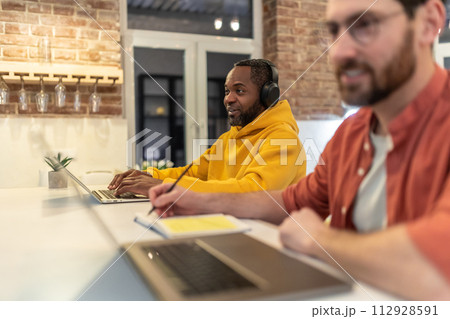 Two men looking involved while working in a home office Two men looking involved while working in a home office 112928591