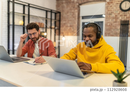 Two men working together in a home office 112928608