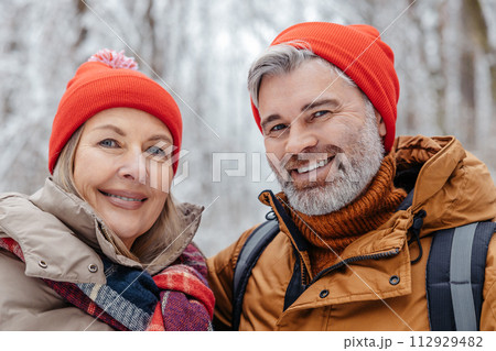 Happy mature couple in a snowy forest 112929482