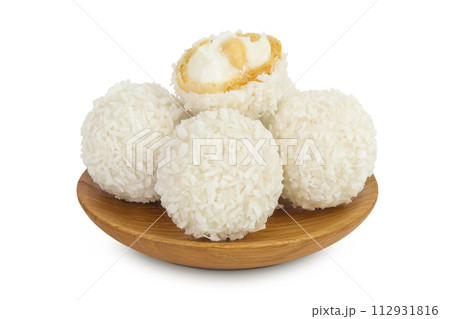 round candy raffaello with coconut flakes and nut in wooden bowl isolated on white background 112931816
